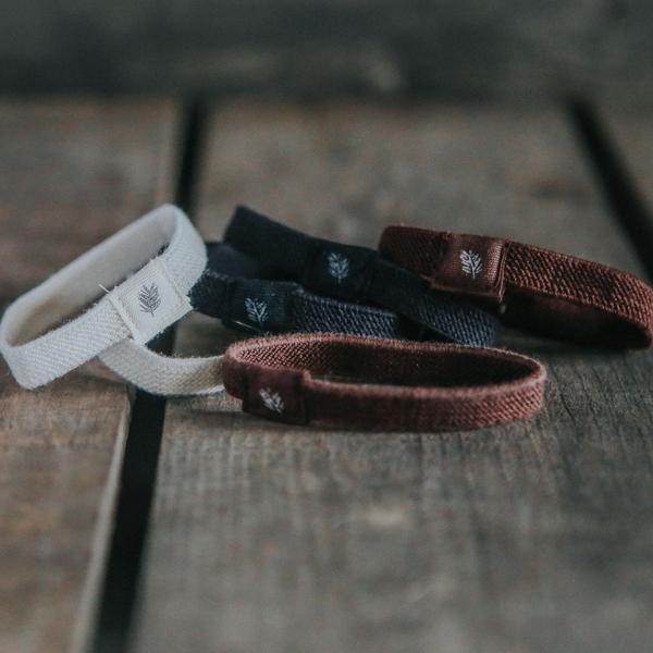 Plastic-free eco-friendly hair bands/ hair ties natural colours, lying scattered on a wooden table