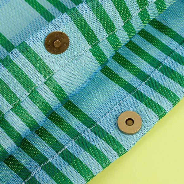 Recycled cement sack in 'Ocean' colourway (blue and green stripes) shown very close up with studs to hold together