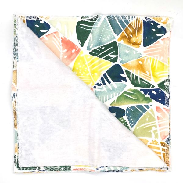 Reusable kitchen towels set of 5 in Bright leaves design (white background with various colourful geometric leaves) shown with one towel folded back to see white alternative soft cotton back