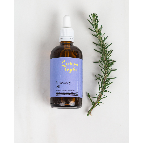 Rosemary oil for skin and hair shown in glass bottle with white pipette, shown alongside a sprig of rosemary