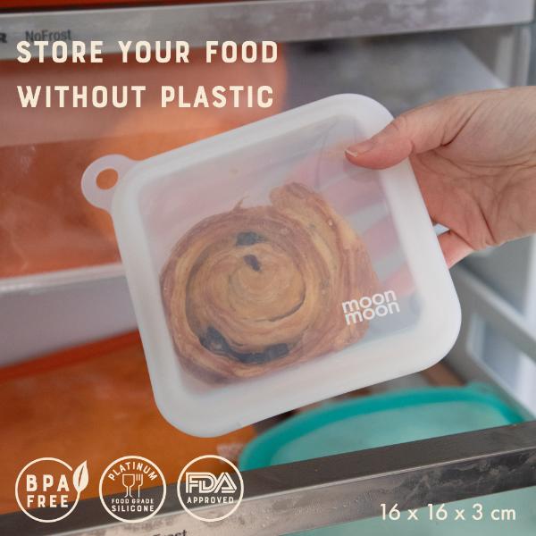 Silicone sandwich case with a bun inside, held by a hand, with text 'Store your food without plastic' and logos reading BPA free, platinum food grade silicone and FDA approved