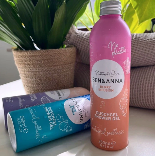 Ben and Anna shower gels in colourful aluminium bottles shown alongside pot plants