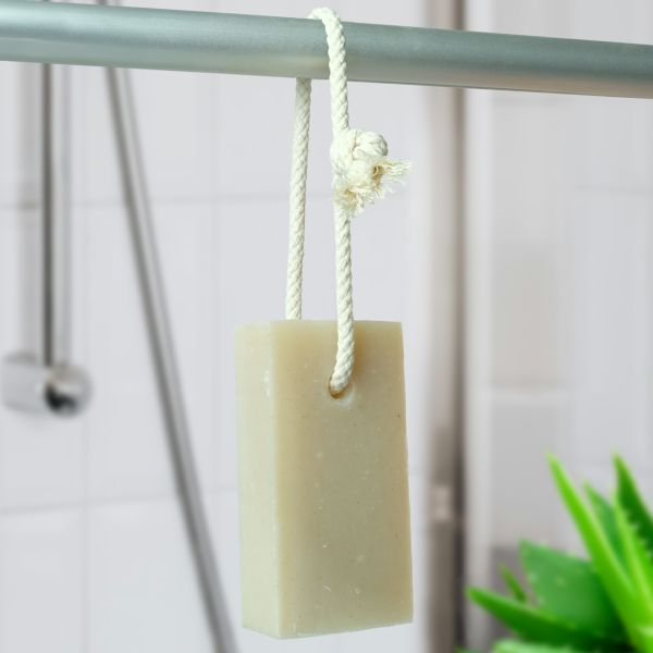 Friendly Soap soap on a rope shown hanging from a shower rail