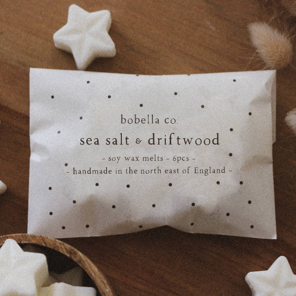 Soy wax melts in sea salt and driftwood shown in packaging and alongside