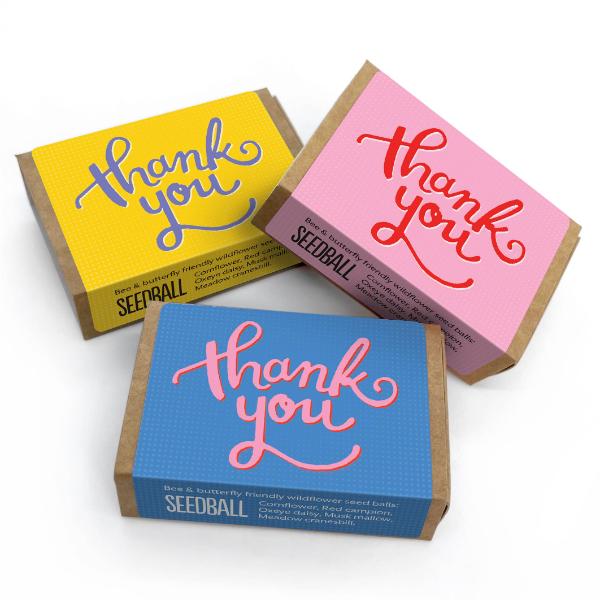Three colourful seedball boxes with 'thank you' text on a white background