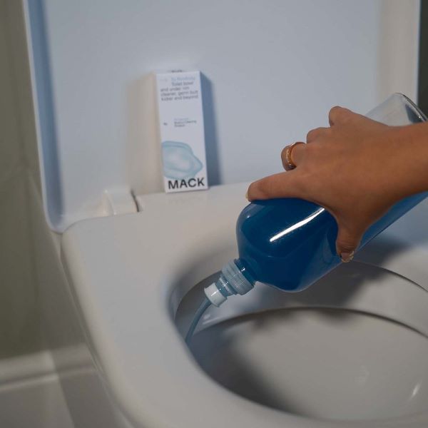 Toilet descaler in bottle being applied to toilet