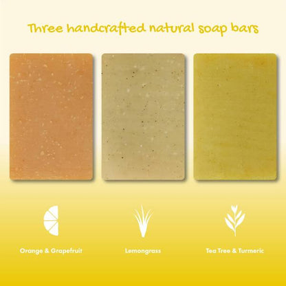 Three rectangular handcrafted natural soap bars displayed side by side on a yellow gradient background, labelled Orange & Grapefruit, Lemongrass, and Tea Tree & Turmeric.
