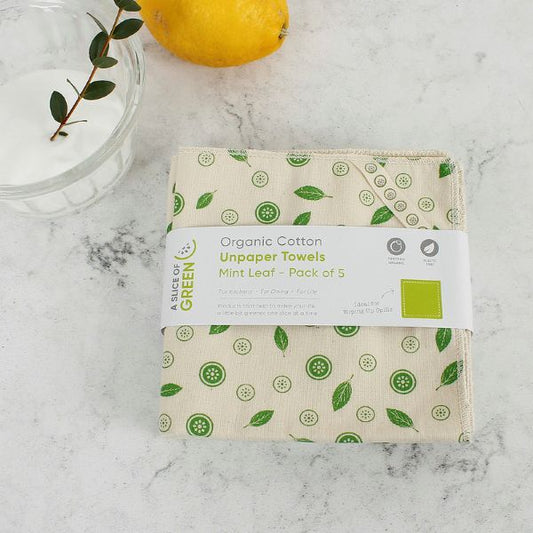 Pack of organic cotton unpaper towels with mint leaf design on a marble surface with paper label