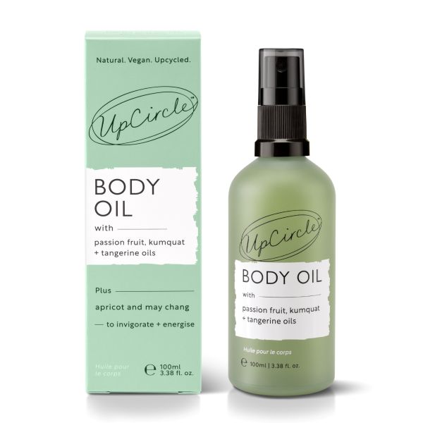 UpCircle body oil bottle alongside cardboard packaging on a white background