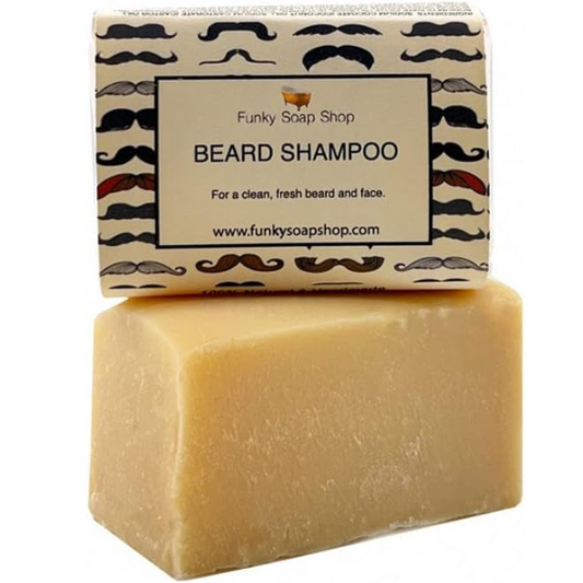 Unwrapped beard shampoo bar with a paper-wrapped bar balanced on top