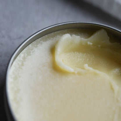 Miracle worker balm in tin packaging with lid off showing contents inside