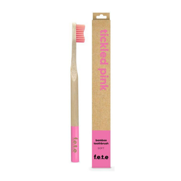 Bamboo toothbrush tickled pink (pink bristles and tip of brush) shown alongside cardboard box