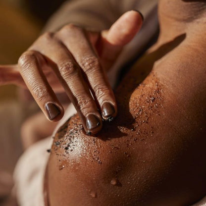 Coffee body scrub from UpCircle lemongrass in use on shoulder