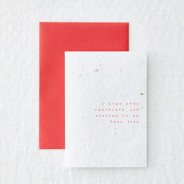 Christmas card saying 'I hope your chestmuts are roasted in an open fire' with red envelope