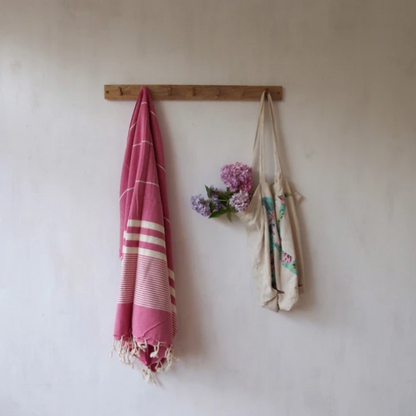 Eco-friendly hammam towel Berry hanging on a wooden hook