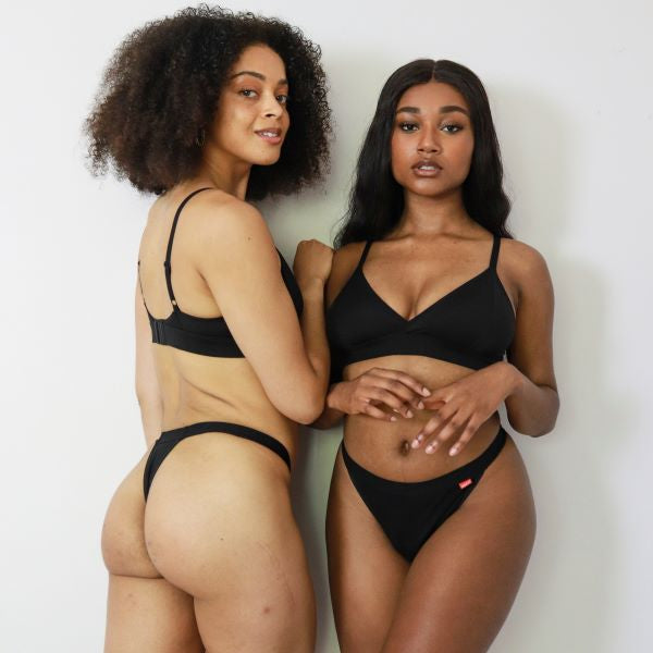 Two people wearing period pants in thong style