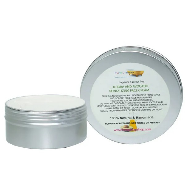 Face cream in aluminium tub Jojoba and avocado shown with lid off and white cream inside